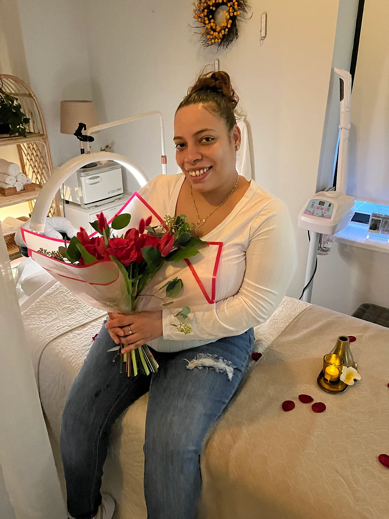 A smiling guest with a bouquet of roses after her treatment
