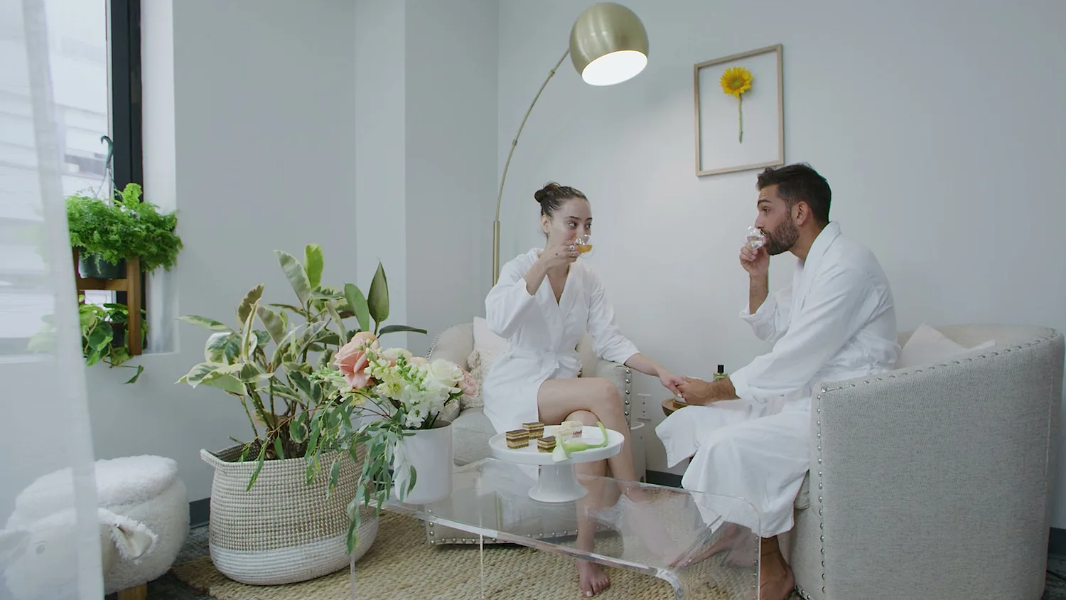 A couple in robes sharing tea and macarons after their ritual