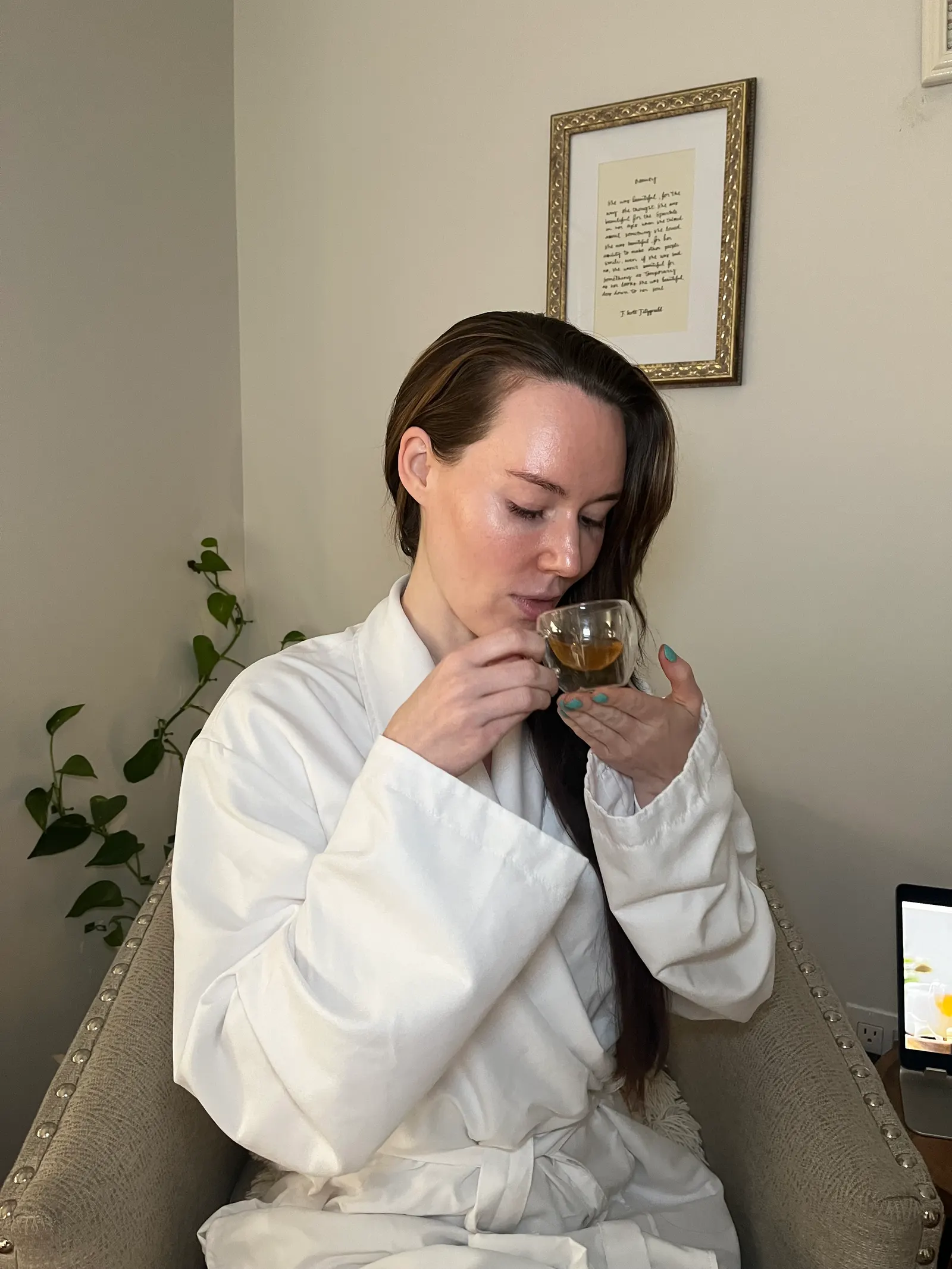 A guest in a robe enjoying the complimentary ceremonial tea after her treatment